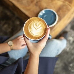 a woman's hands holding a cup of coffee