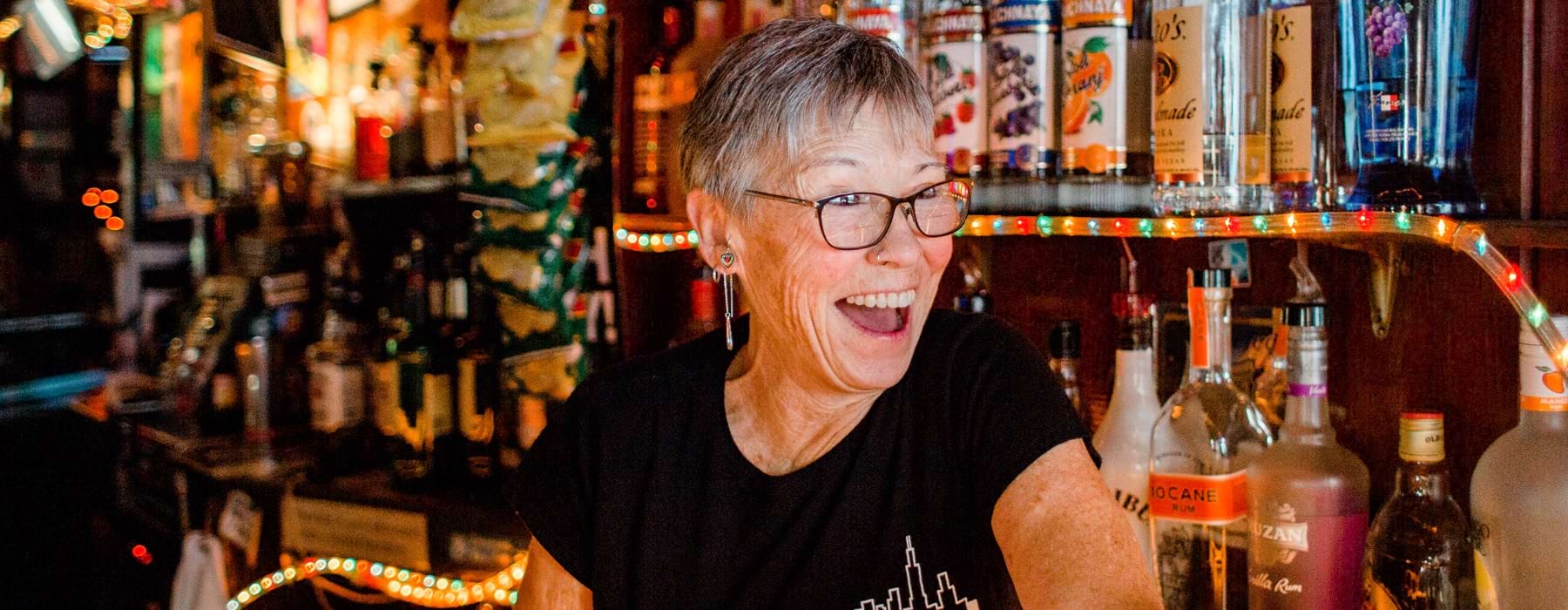 bartender smiling at customers from behind the bar