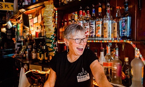 bartender smiling at customers from behind the bar